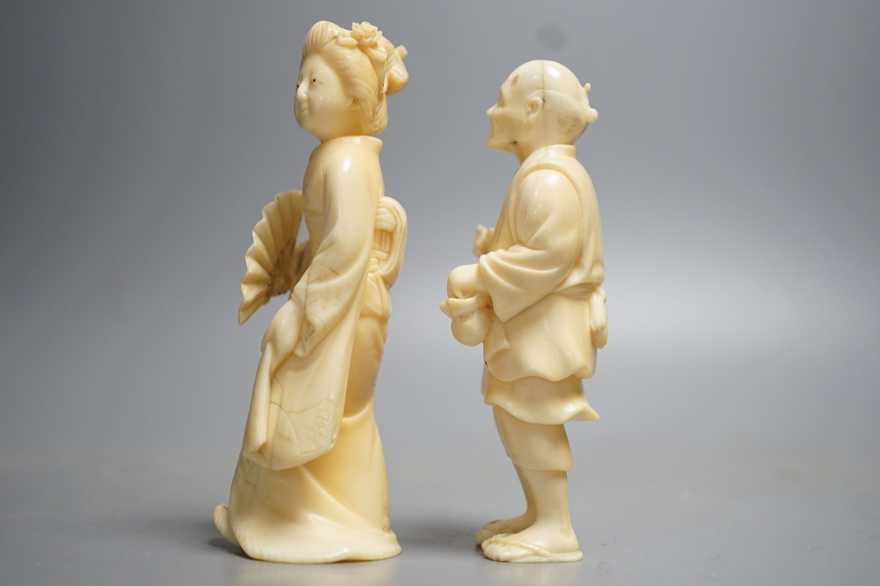 Two Japanese ivory figures of a man and a bijin, Meiji period, both signed to base, 10cm